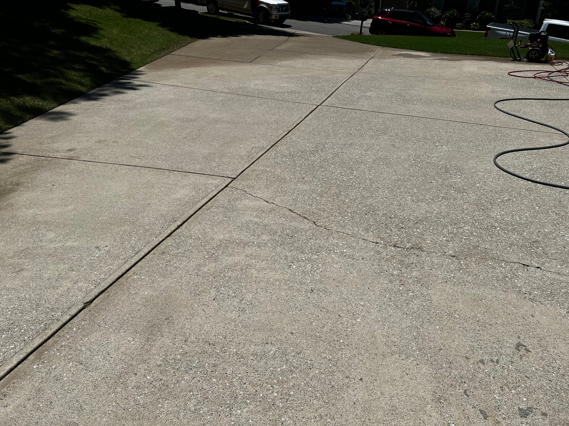 Same concrete driveway after pressure washing, stains lifted